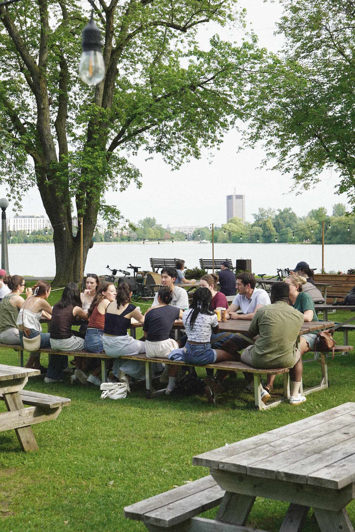 Une foule rassemblée aux tables à pique-nique au bord de l’eau à la Buvette du Lac, lac Dow